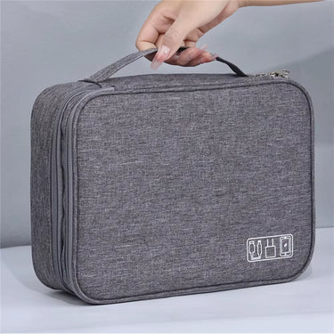 Trousse de rangement multifonction gris avec poignée portable. Parfaite pour transporter vos accessoires électroniques et cosmétiques en toute simplicité.